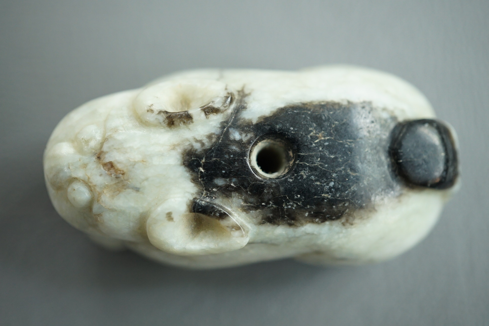 A Chinese white and black jade figure of a recumbent tiger, Song dynasty